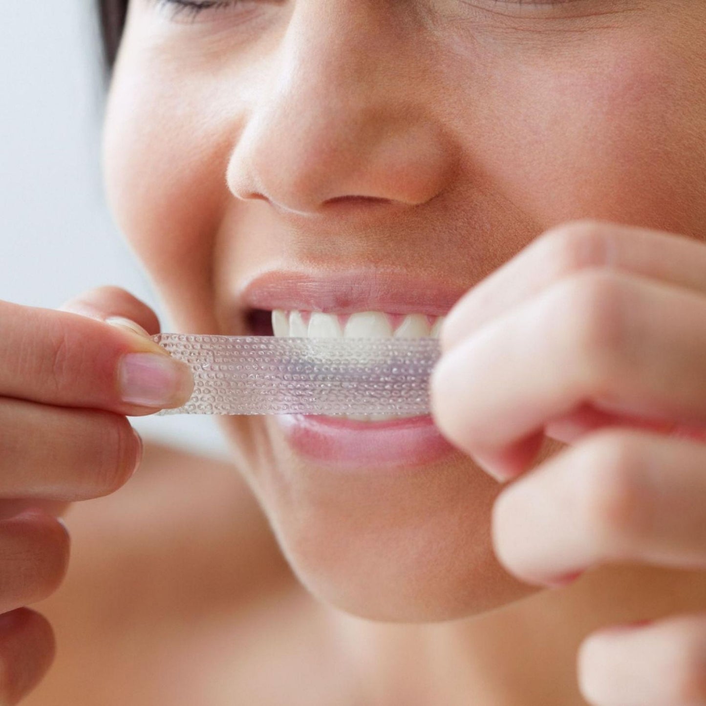 Aanbrengen van LucidBite whitening strip op tanden voor snel wittere tanden zonder gevoeligheid